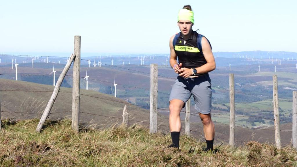 David Pollán en lo alto de una colina; tras él, decenas de molinos de viento