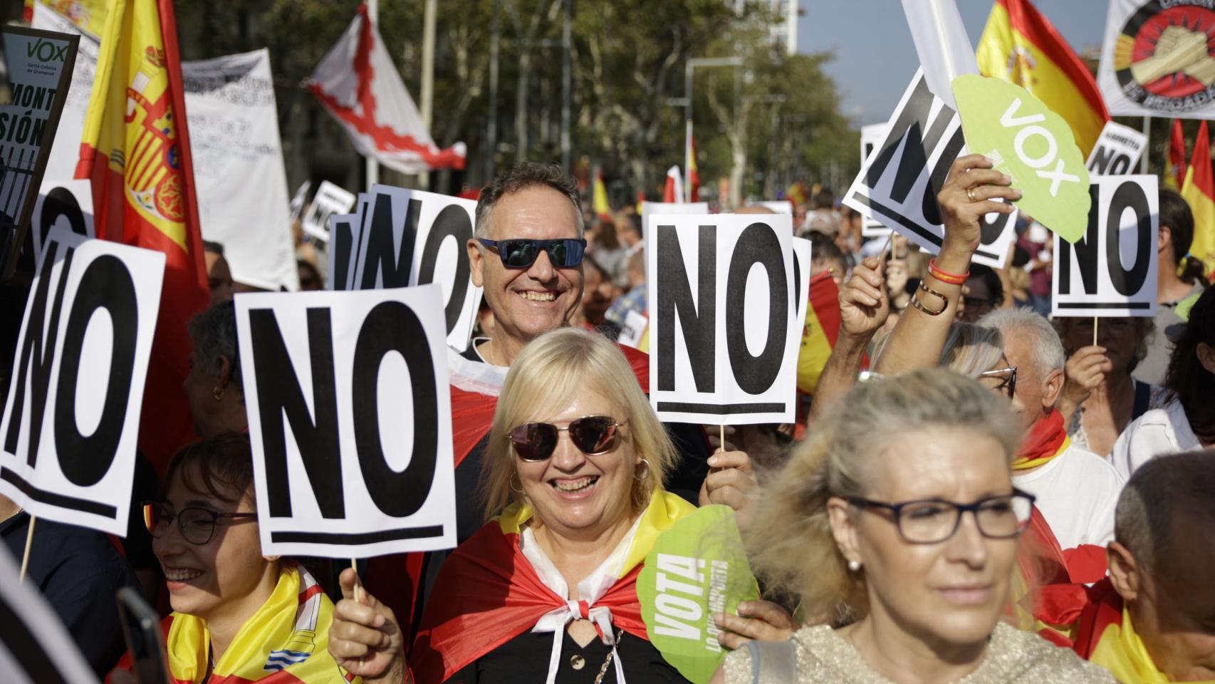 Decenas de personas acuden a la manifestación contra la amnistía con carteles en contra de ella con el lema 'NO'.