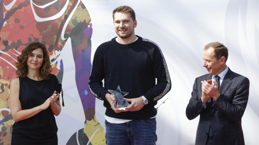 La presidenta de la Comunidad, Isabel Díaz Ayuso, junto al escolta de los Dallas Mavericks Luca Doncic (c) y el director de Relaciones Institucionales del Real Madrid, Emilio Butragueño (d), durante la presentación del partido amistoso de baloncesto que disputarán el Real Madrid y los Dallas Mavericks