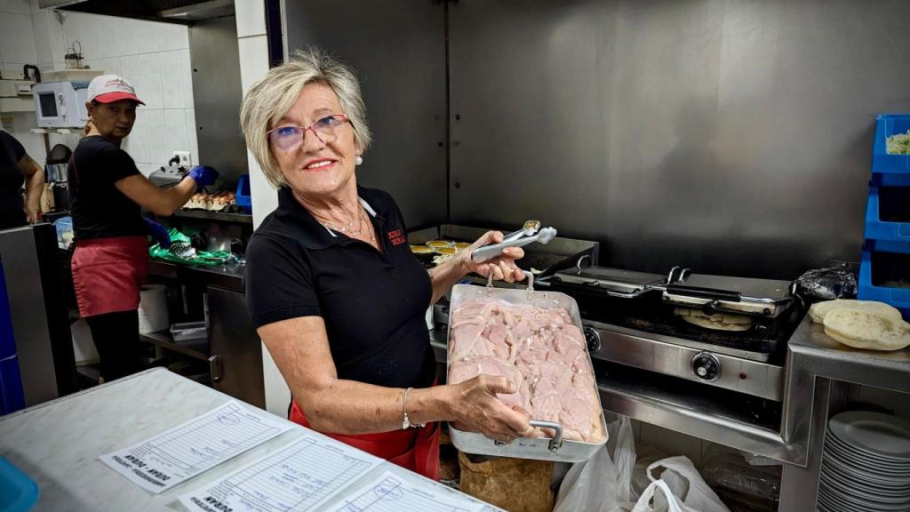 Pepi posa con la bandeja de pollo.