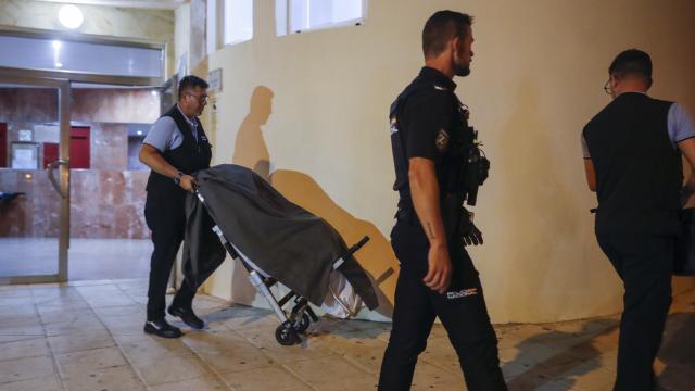 Imagen del traslado de uno de los cadáveres encontrados en una vivienda de Benalmádena.