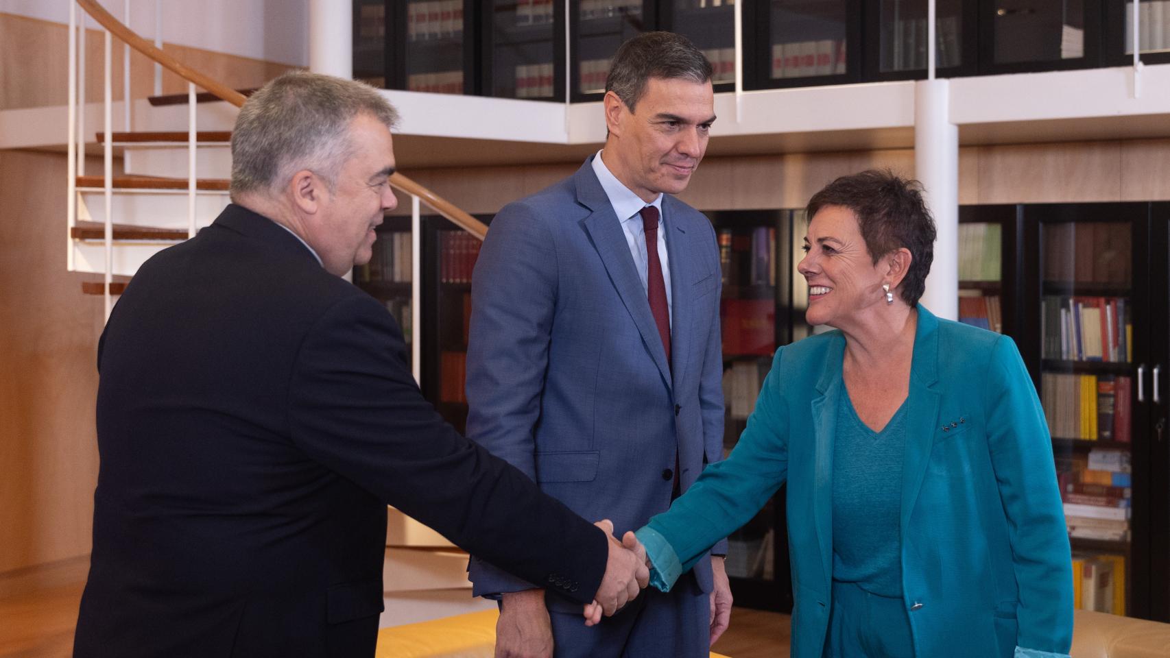 Mertxe Aizpurua saluda a Santos Cerdán, secretario de Organización del PSOE, en presencia del presidente del Gobierno, Pedro Sánchez, en el Congreso de los Diputados, este viernes.