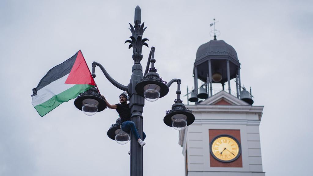 Un manifestante encaramado a una farola en la Puerta del Sol