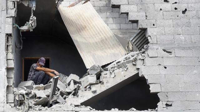 Un hombre sentado entre los escombros tras un ataque israelí a una casa en Gaza.