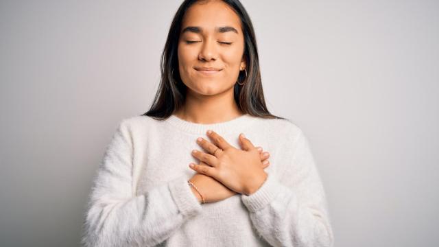 Mujer con las manos en el pecho como signo de agradecimiento.