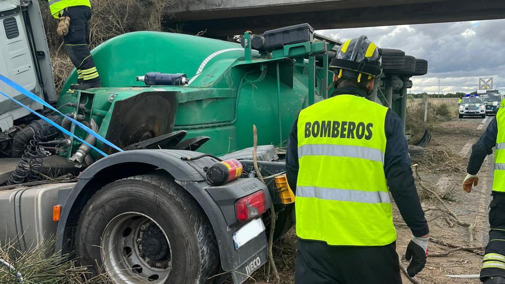 Los bomberos extraen al camionero que se encontraba atrapado en el interior del vehículo.