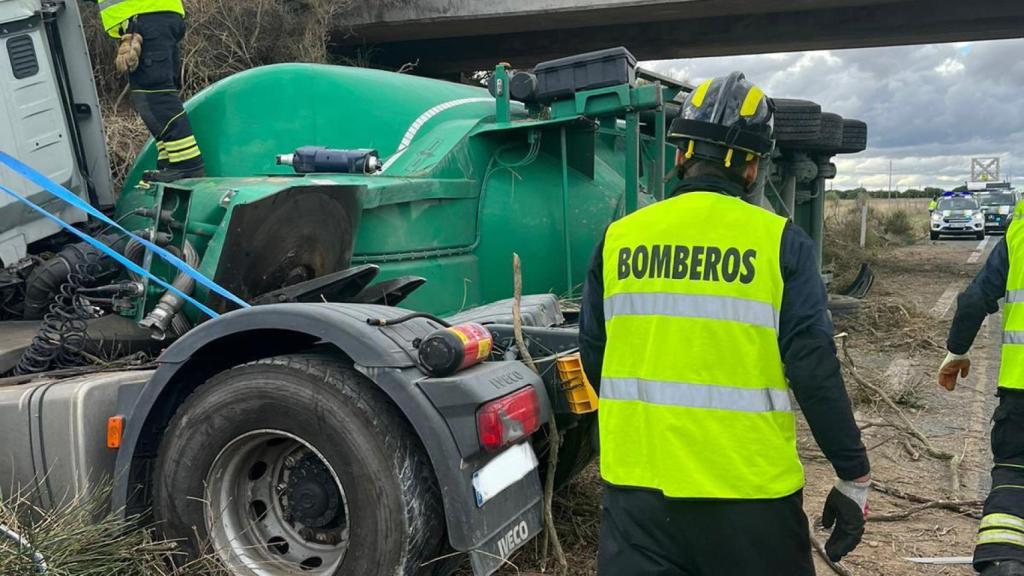 Los bomberos extraen al camionero que se encontraba atrapado en el interior del vehículo.