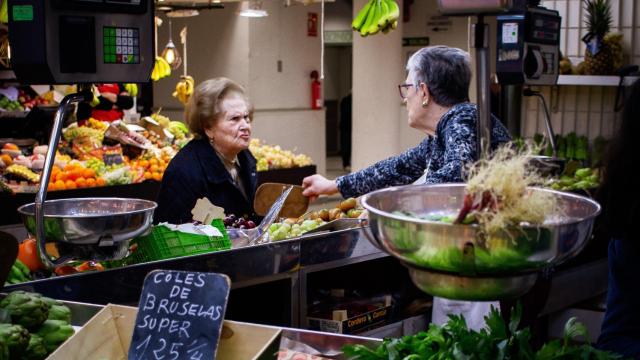 Una cliente y una vendedora en un puesto del Mercado Central de Alicante.