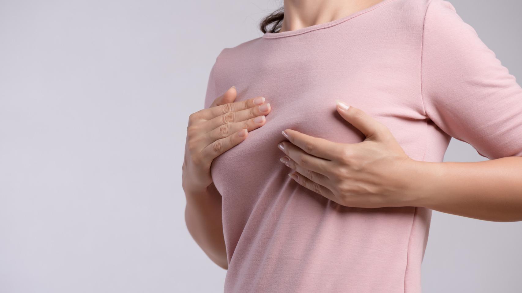 Una mujer autoexplorándose las mamas.