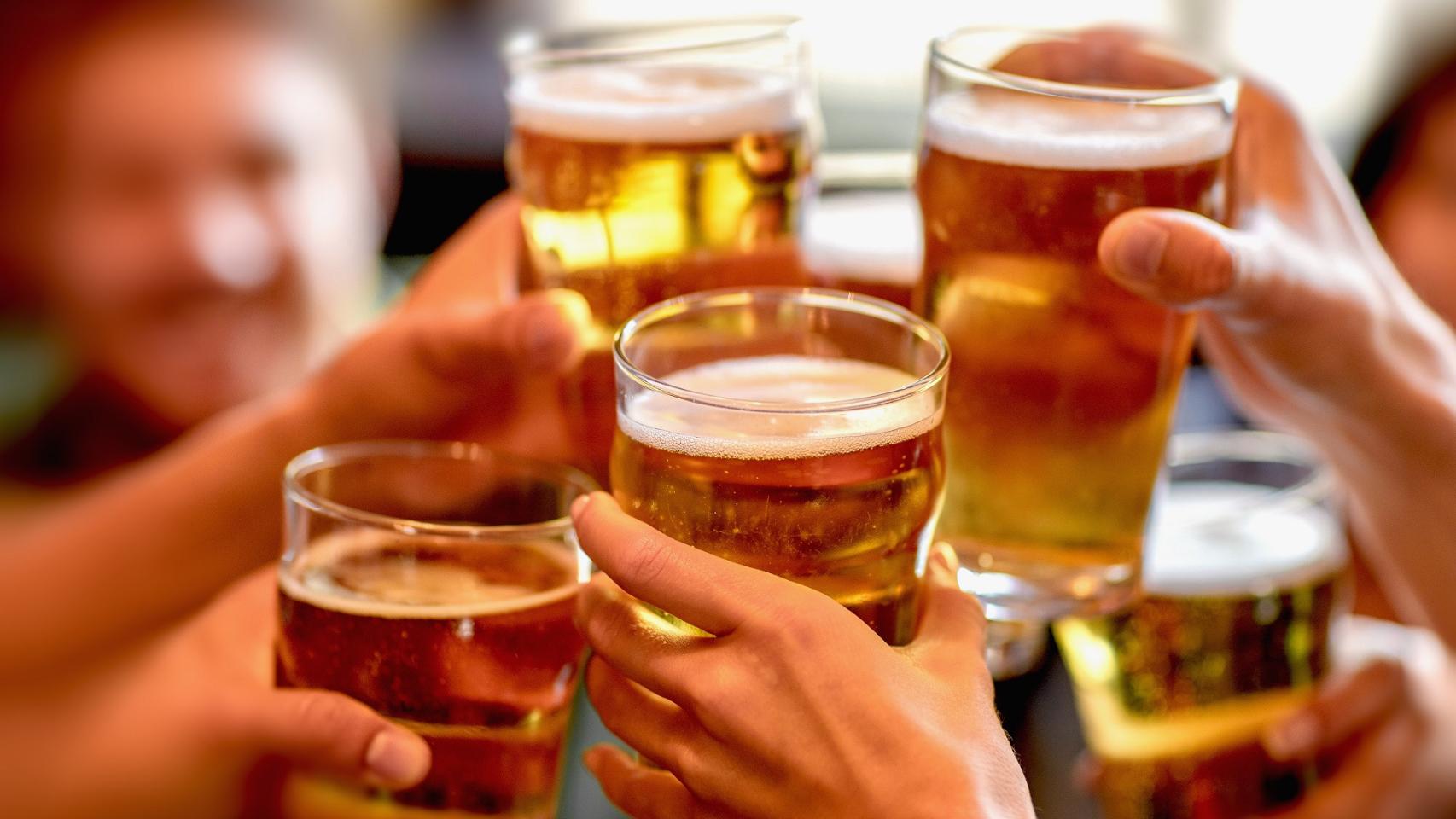 Un grupo de personas brinda con cerveza.