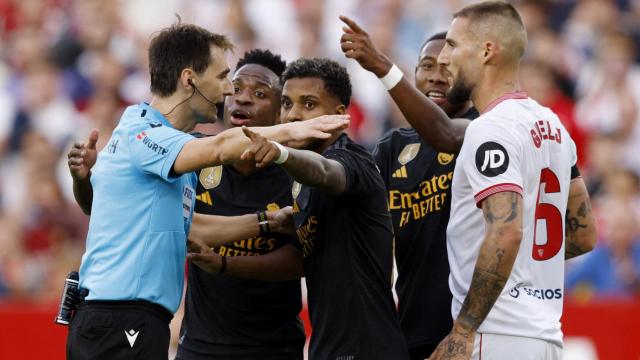 De Burgos Bengoetxea, acorralado por jugadores del Sevilla y del Real Madrid.