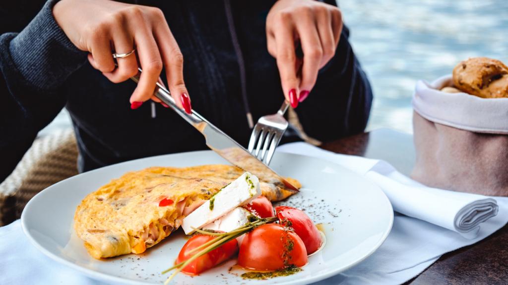 Imagen de un plato con una tortilla, ensalada de tomate y queso fresco.