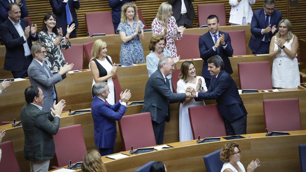 El presidente Mazón saluda a los diputados del PP después de su discurso de investidura. EE