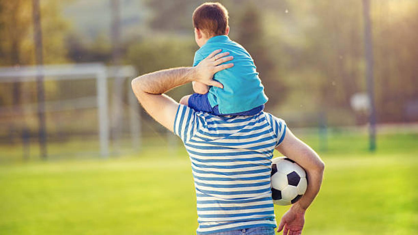 Un padre lleva a su hijo en hombros.