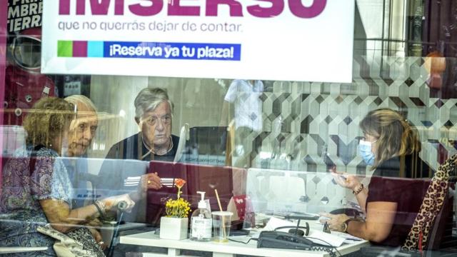 En la imagen, varias personas mayores piden información en una agencia de viajes adherida al programa.