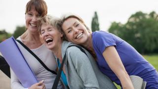 Imagen de un grupo de mujeres riendo tras una clase de yoga.