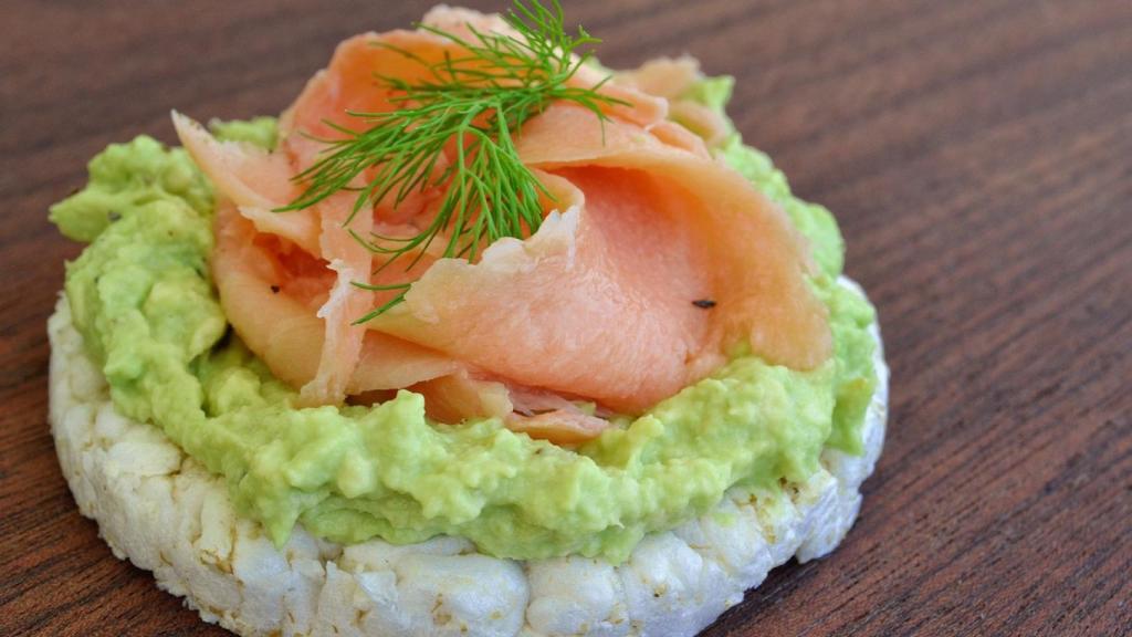 Salmón ahumado con guacamole sobre tortita de arroz.