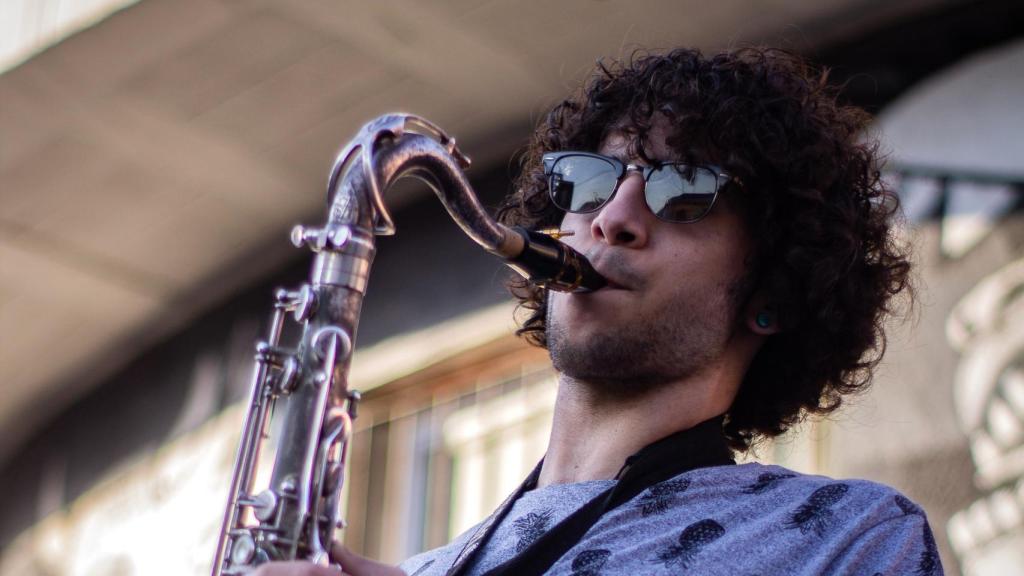 Un saxofonista tocando delante del mural de Guernica, durante un concierto en el barrio de San Isidro.