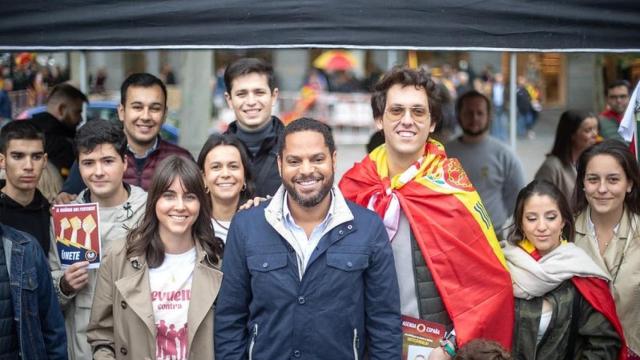 Ignacio Garriga, secretario general de Vox, junto a jóvenes de Revuelta, el pasado 29 de octubre en la madrileña Plaza de Colón.