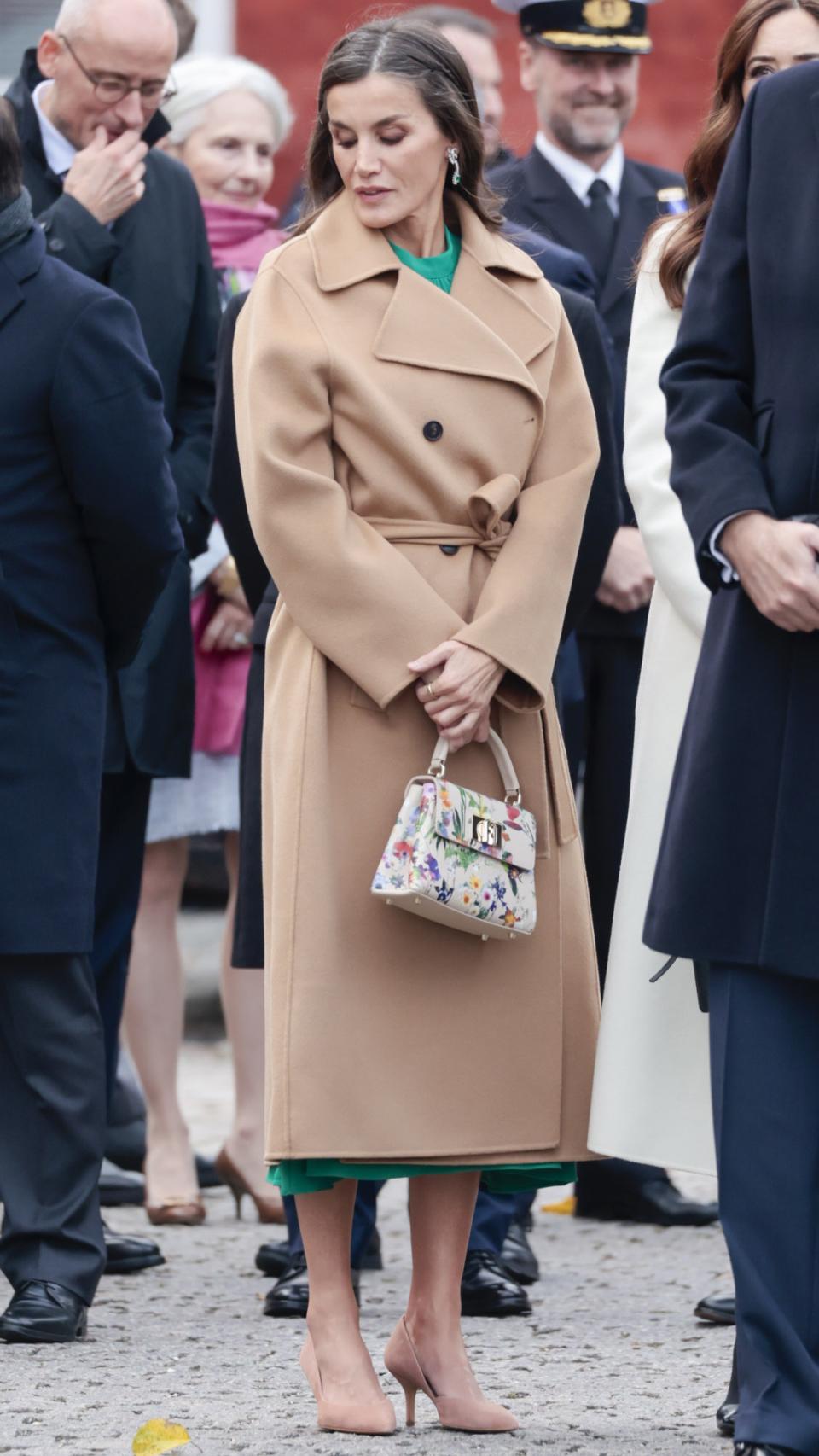 Letizia, con abrigo batín en camel y su bolso de Furla.