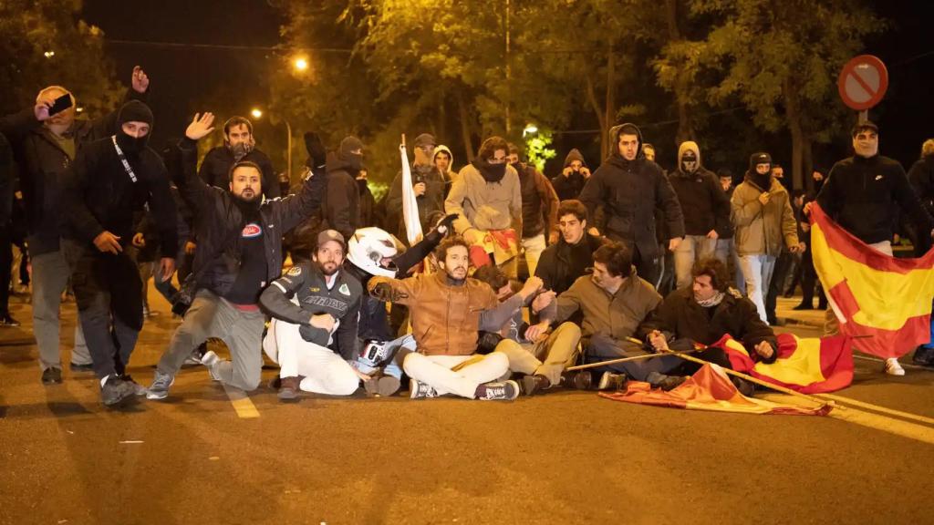 Un grupo de manifestantes despliega una sentada frente a los servicios de UIP, durante la protesta en las inmediaciones de la calle Ferraz, en Madrid.