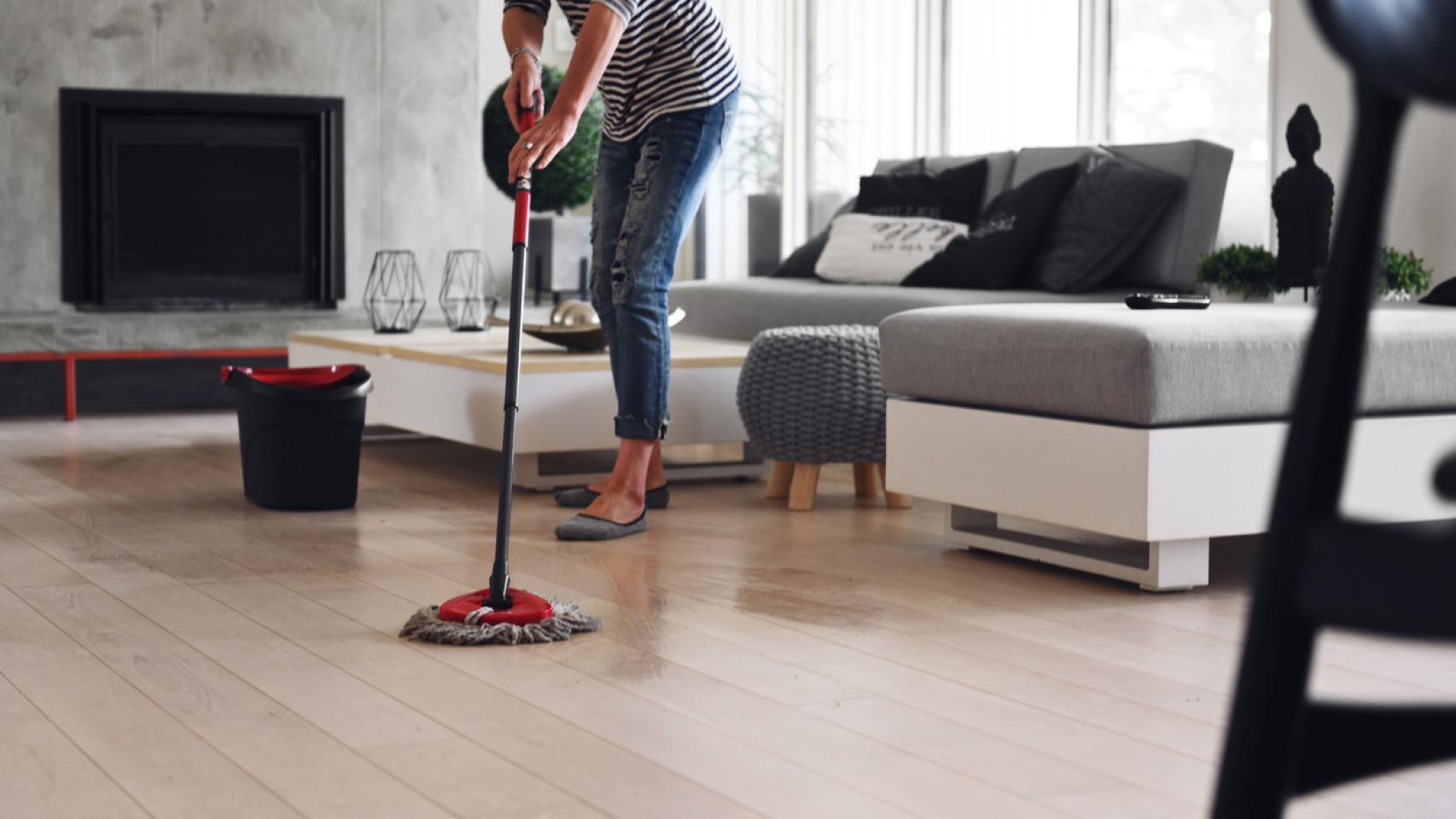 Mujer fregando el suelo de una casa.