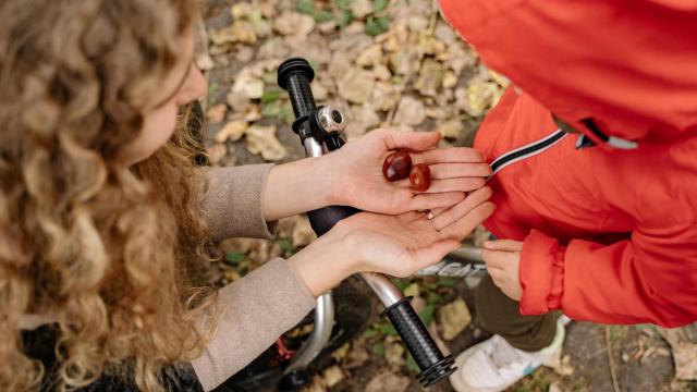 Imagen de una mujer dando castañas a una niña.