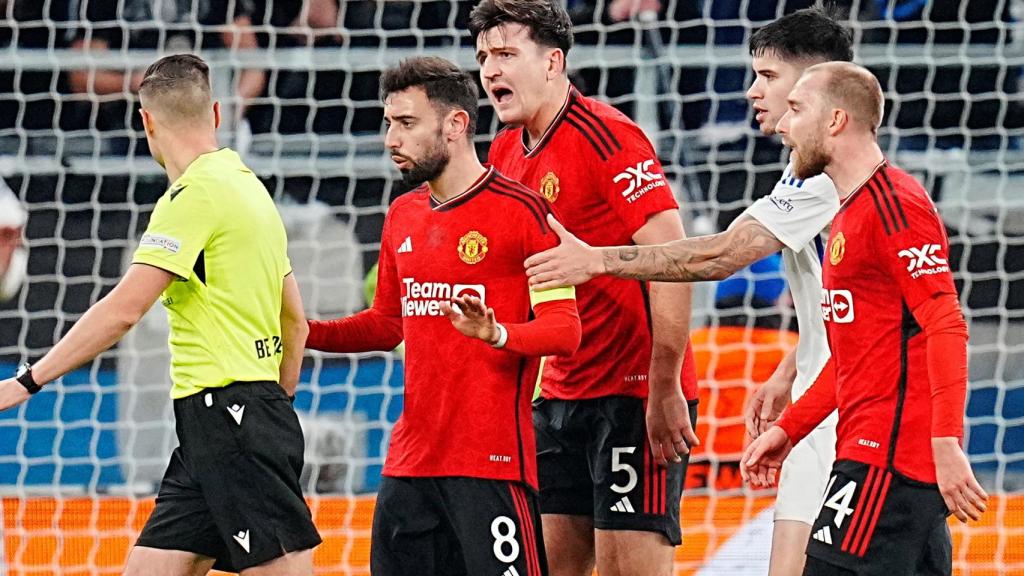 Maguire y varios jugadores del United persiguen al árbitro Donatas Rumsas.