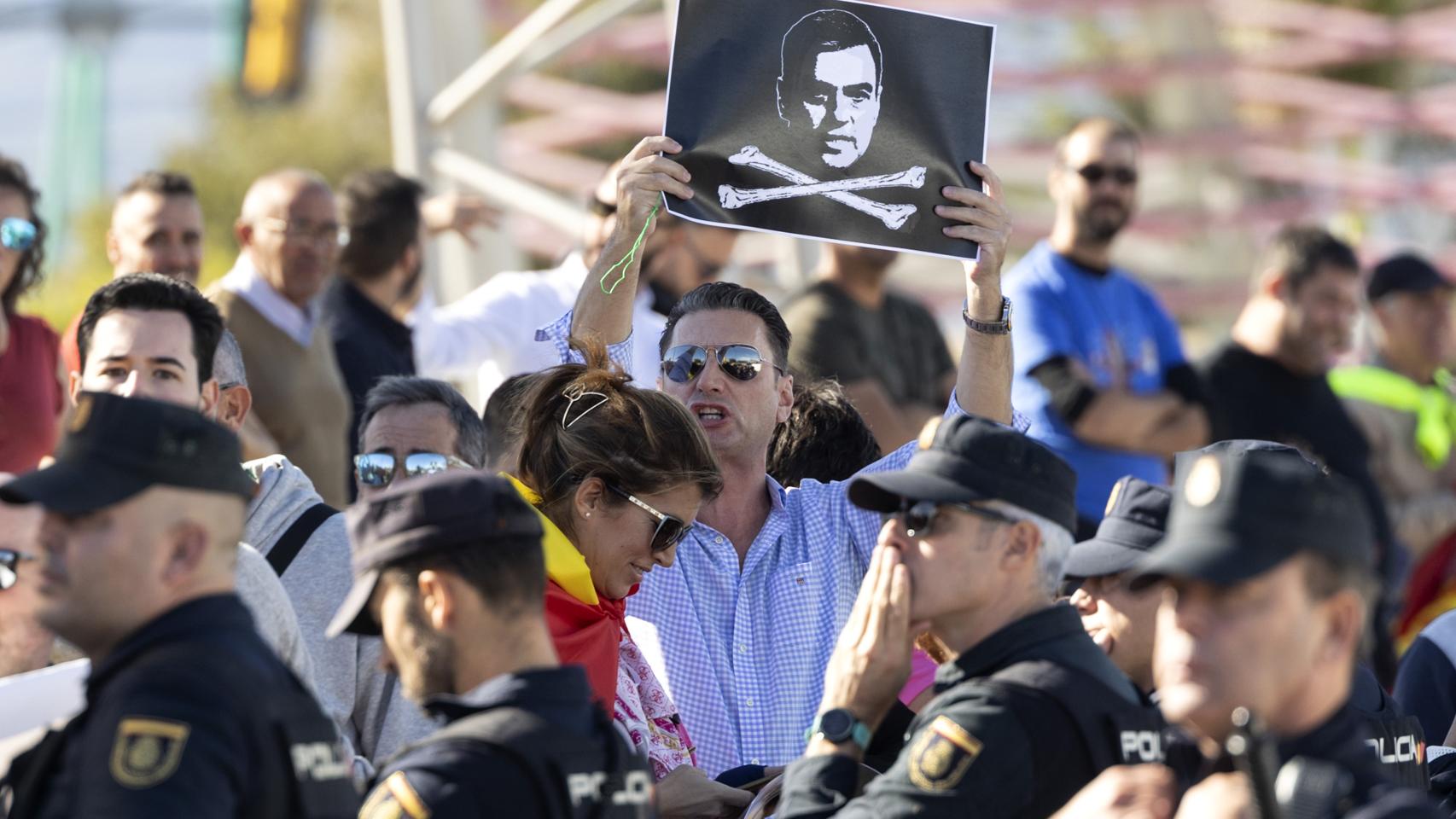 Un manifestante con una imagen de Pedro Sánchez.