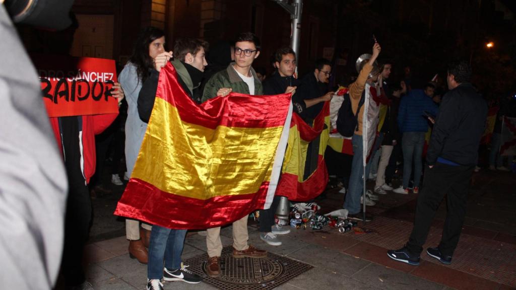 Varios jóvenes frente a una fila formada por antidisturbios