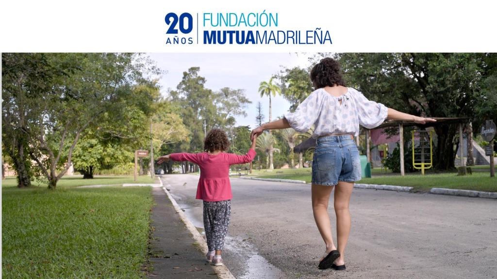 Imagen de archivo de una madre divirtiéndose con su hija en la calle.