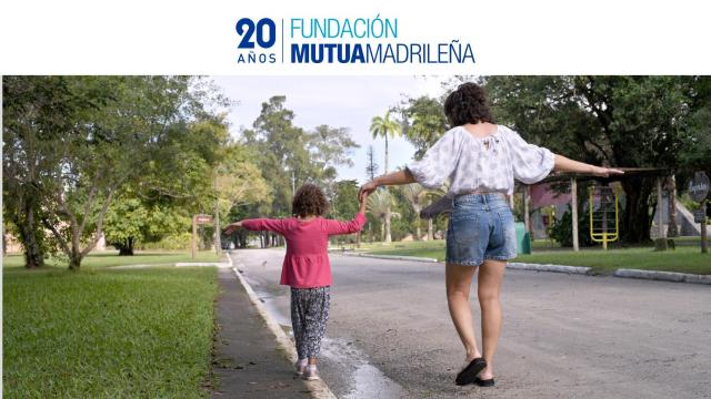 Imagen de archivo de una madre divirtiéndose con su hija en la calle.