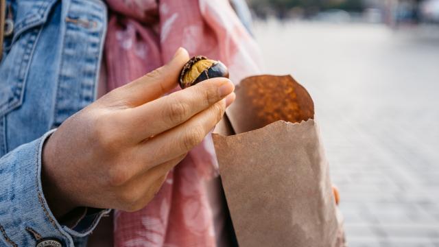 Imagen de una mujer pelando una castaña