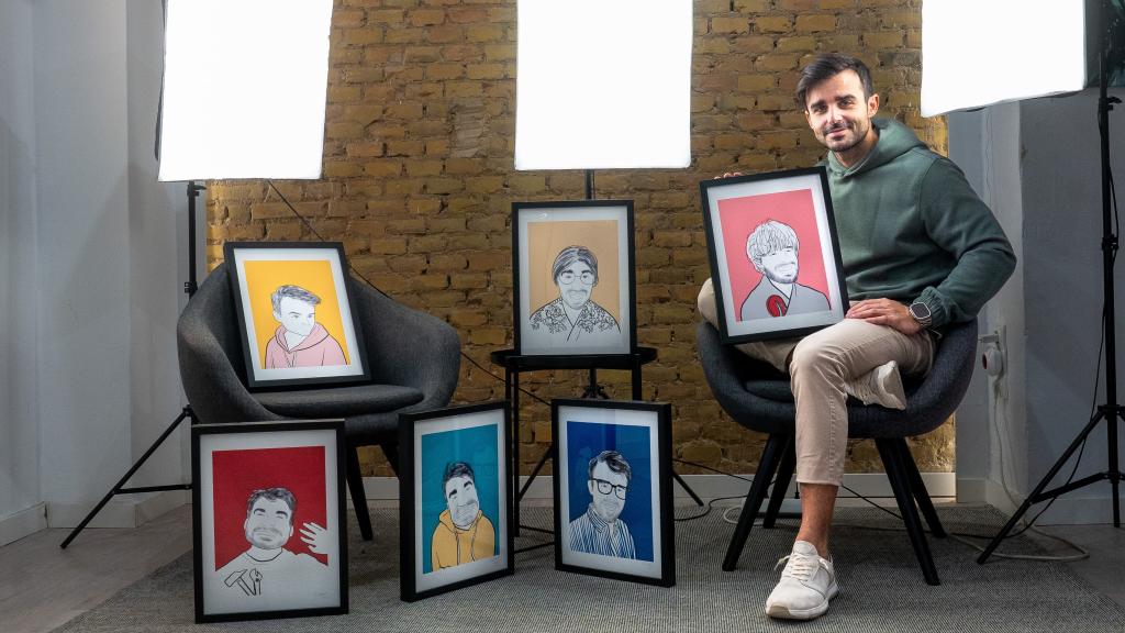 Nachter, posando con los cuadros de los personajes que ha creado que aparecen en sus contenidos.