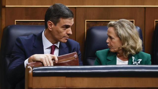 Pedro Sánchez, secretario general del PSOE y presidente del Gobierno en funciones, conversa con la vicepresidenta económica en funciones, Nadia Calviño, en el Congreso, durante el primer día del debate de su investidura.