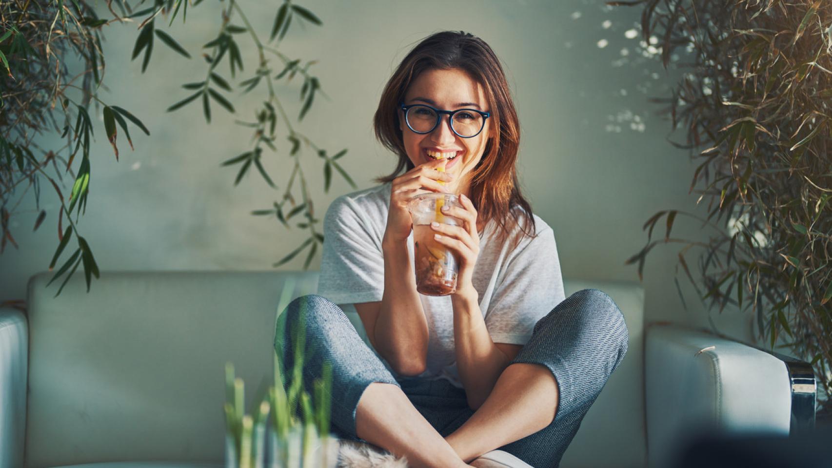 Mujer sonriente bebiendo una infusión