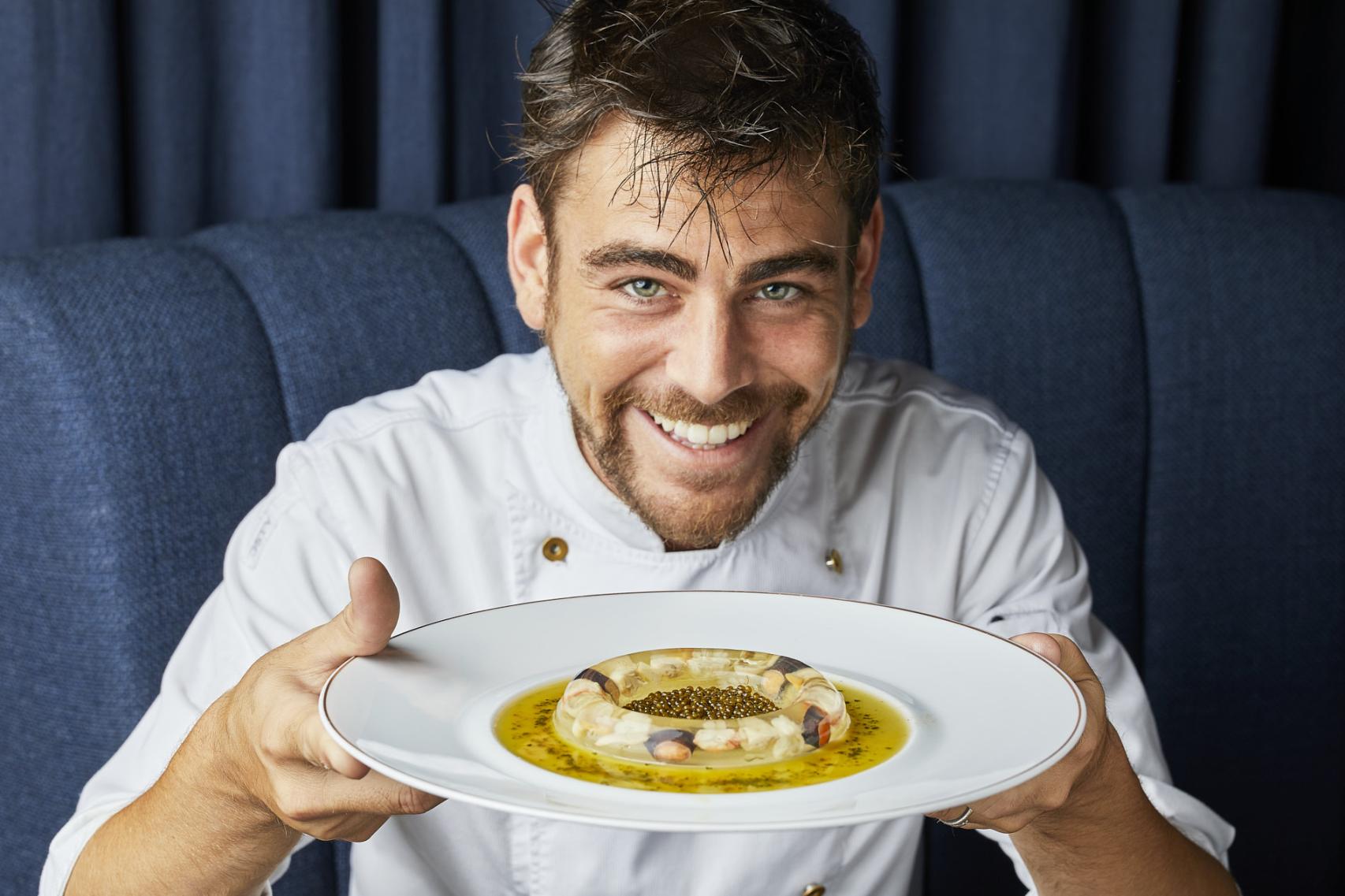 El chef Gonzalo Hernández, sujetando uno de los platos que ofrece en el restaurante Amar.