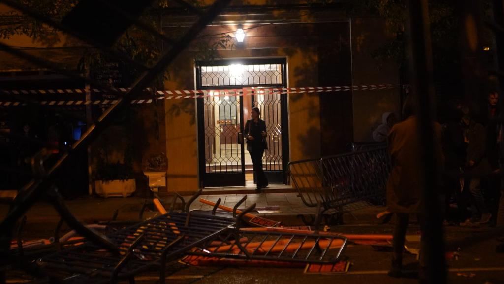Una mujer sale de su casa corriendo frente a la línea de manifestantes