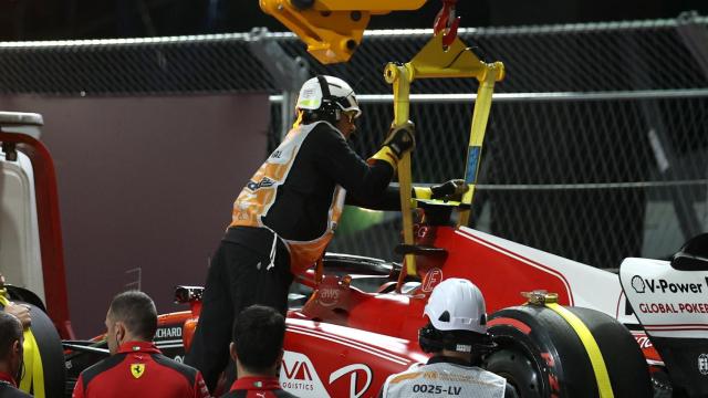 El Ferrari de Carlos Sainz siendo retirado tras el incidente con la alcantarilla.