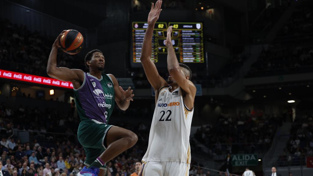 El pívot caboverdiano del Real Madrid Walter Tavares (d) intenta bloquear el mate de Kameron Taylor, alero de Unicaja durante el partido.
