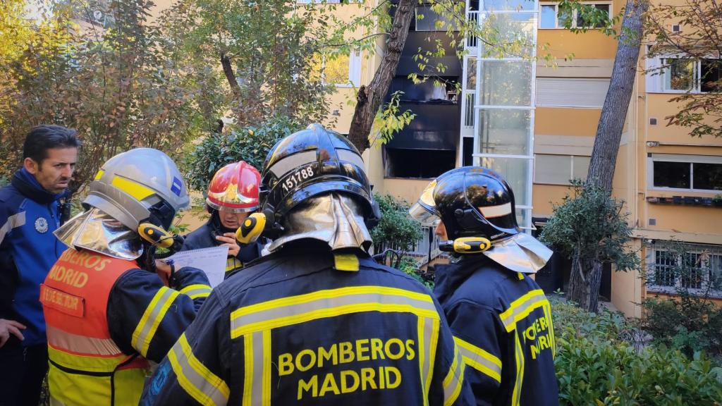 Los bomberos frente a la vivienda calcinada.