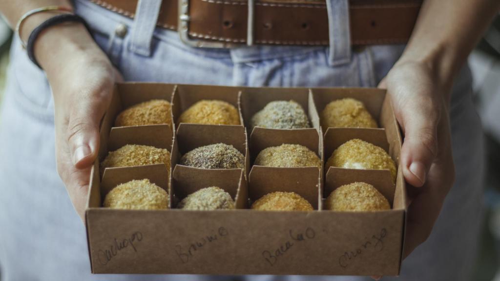 Croquetas de varios sabores empaquetadas para llevar.