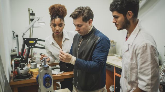 Una pareja en el taller de Jorge Juan Joyeros de Serrano laminado sus alianzas bajo la supervisión del joyero.