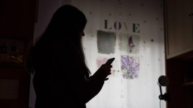 Una chica mirando su teléfono móvil. Save the Children