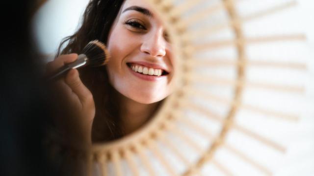 Una mujer aplicándose colorete.