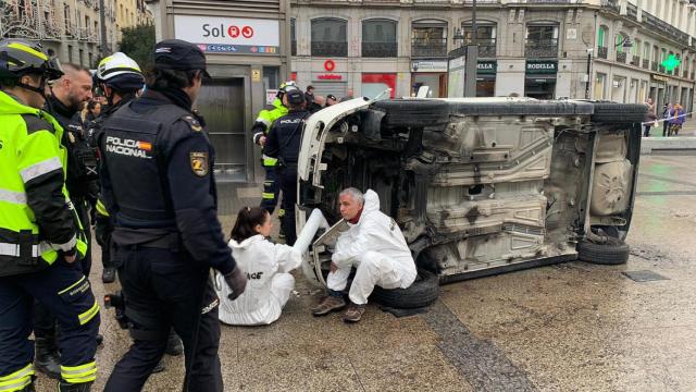 Los activistas junto al coche volcado en la Puerta del Sol.