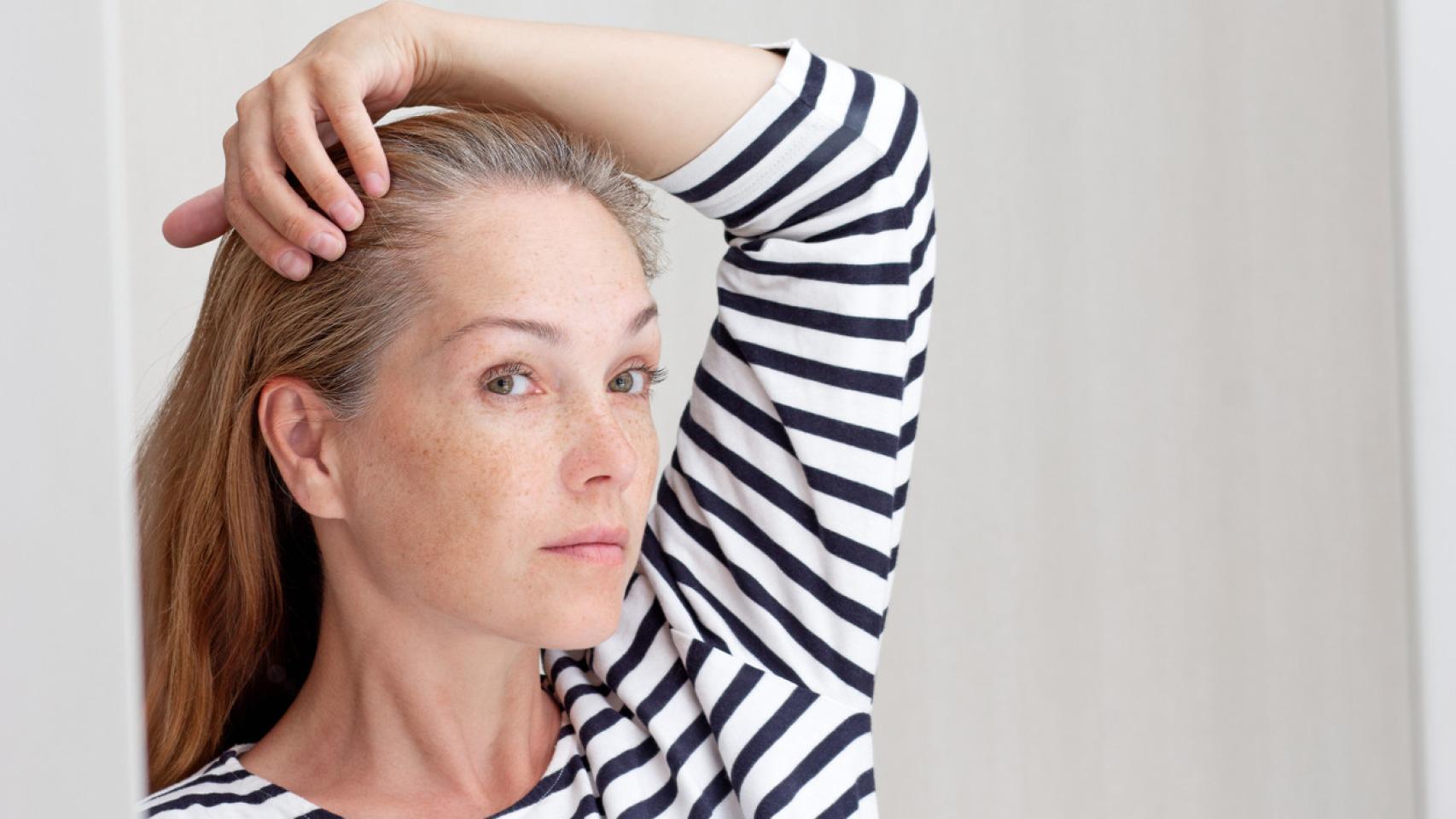 Imagen de una mujer mostrando las canas de su pelo