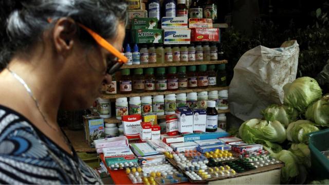 Una mujer pasa junto a un puesto que vende medicinas en la ciudad de Rubio, fronteriza con Colombia.