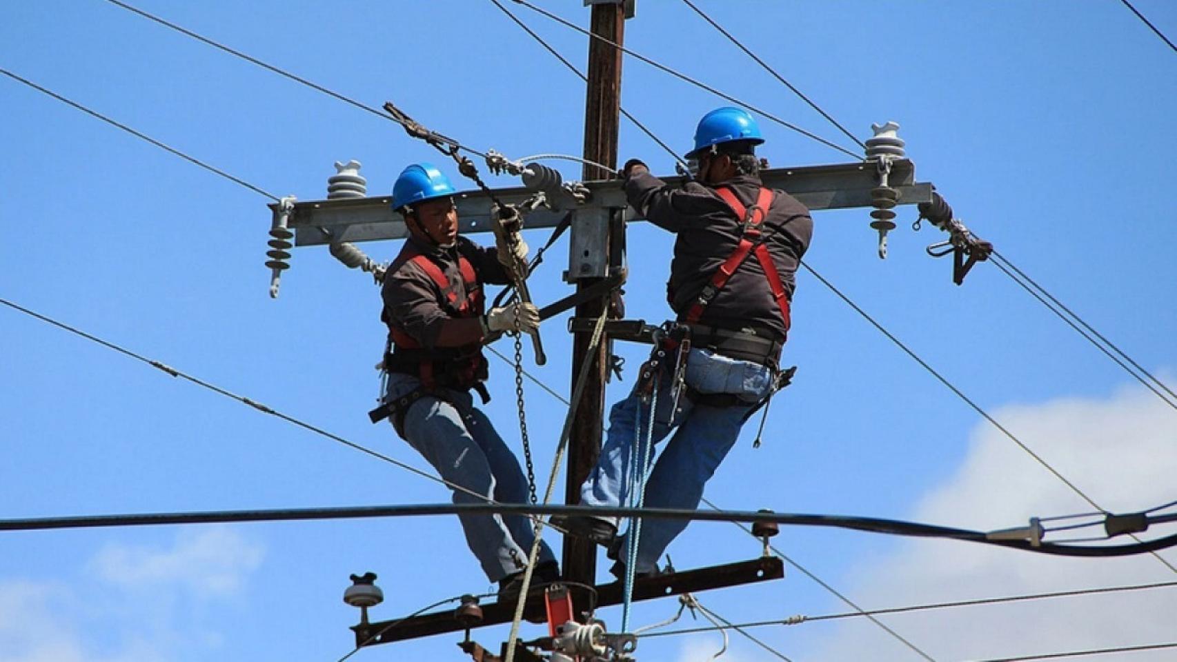 Trabajadores en un poste de telefonía.