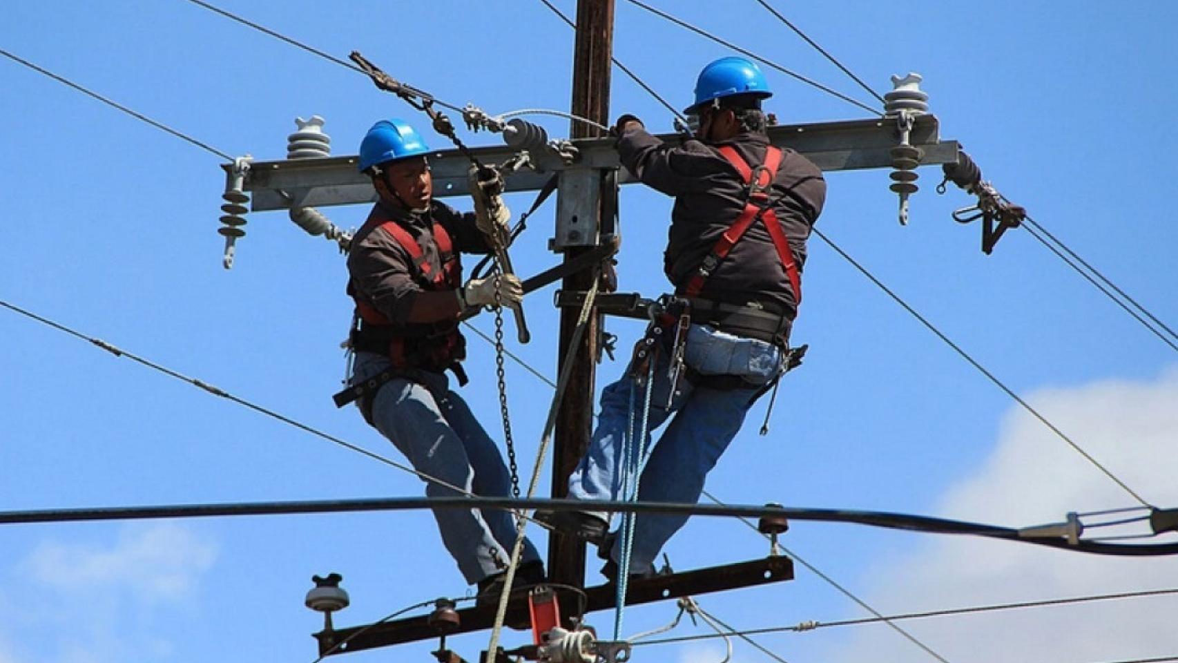 Trabajadores en un poste de telefonía.